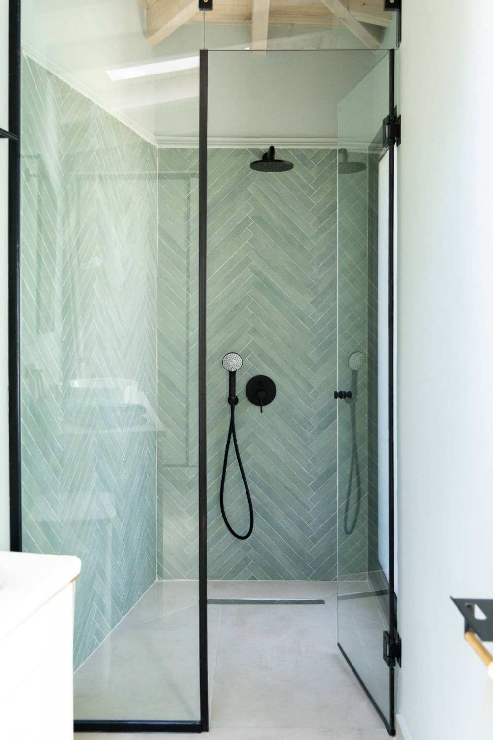 Walk-in rain shower with sage herringbone tile